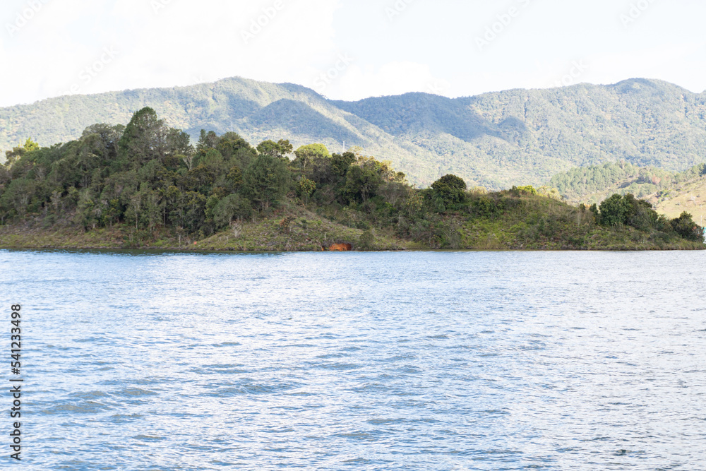 Beautiful natural scenery of sun-drenched mountains, tropical forest and deep lake
