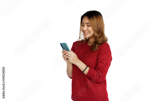 Using mobile, Excited young brunette pretty asian woman isolated on white background, red sweater.