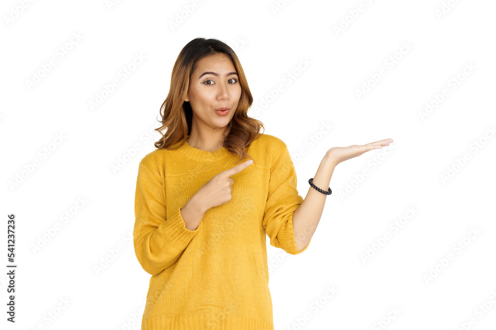 Attractive positive young asian brunette woman in yellow sweater on white background. hands pointing Attractive positive young asian brunette woman in yellow sweater on white background. hands pointing