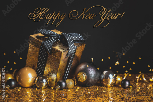 lHappy New Year. Golden box with a gift and Christmas balls on a black and gold background photo