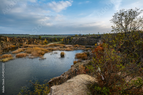 Flooded granite quarry White rocks near village Aktove, Ukraine. Colorful leaves of trees in the autumn landscape, colors of leaf-fall.