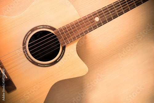Close up front surface of top solid brown wooden grand auditorium acoustic guitar on black background for cover page with copy space