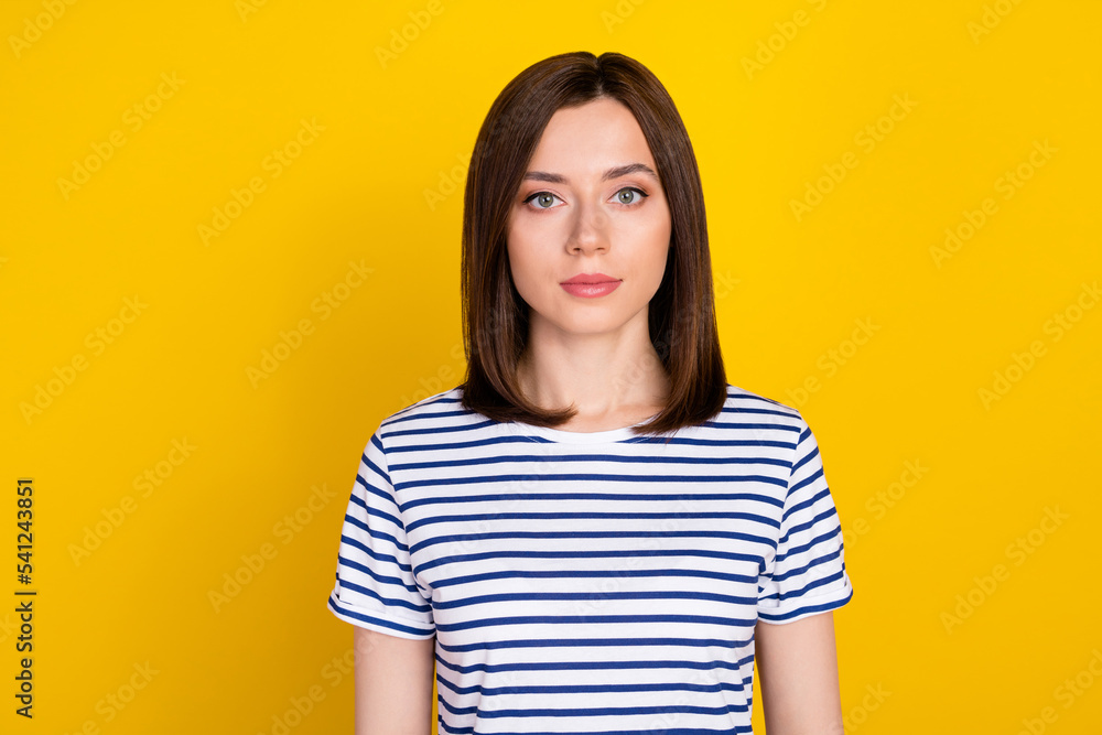 Photo of young gorgeous adorable girl with bob hairstyle dressed striped t-shirt looking at camera isolated on yellow color background Photo of young gorgeous adorable girl with bob hairstyle dressed striped t-shirt looking at camera isolated on yellow color background