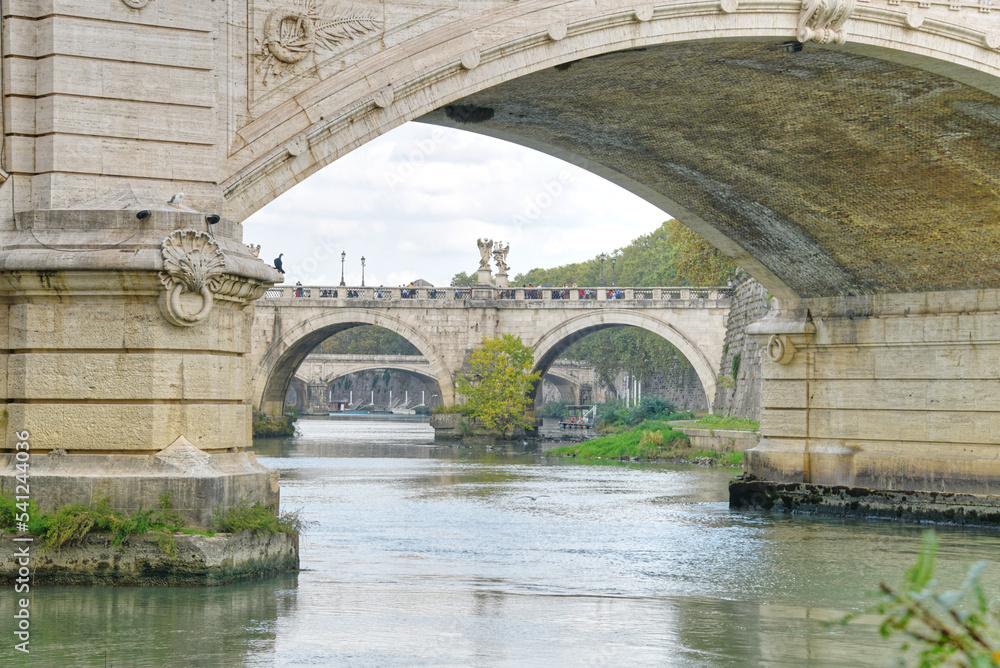 The Saint Angelo bridge spanning the Tiber river in Rome Italy as seen on a fall day.