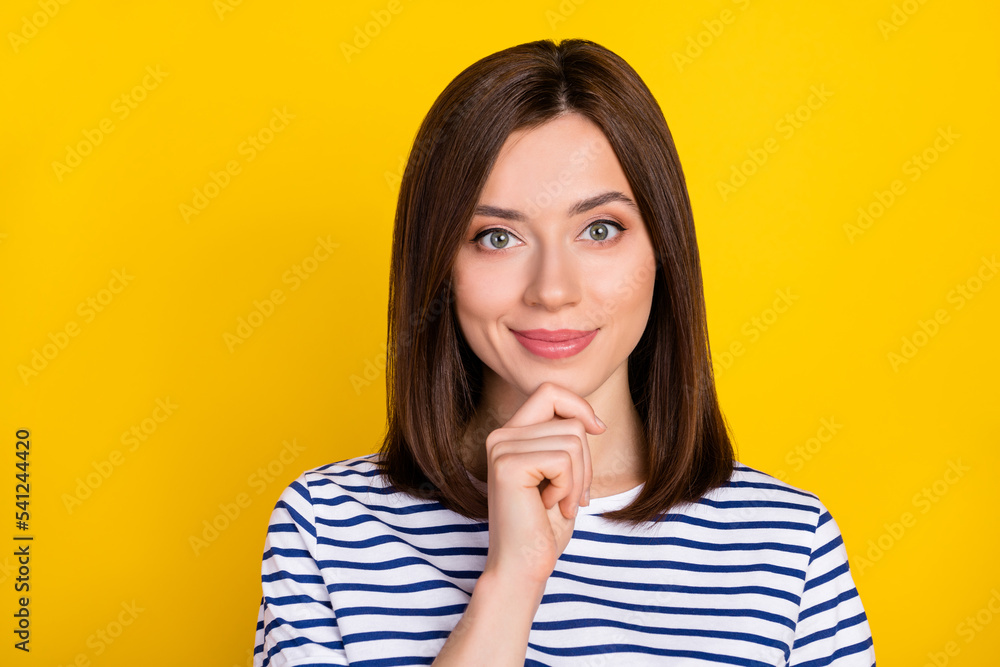 Photo of nice adorable positive girl with bob hairstyle dressed striped t-shirt arm touch chin isolated on yellow color background Photo of nice adorable positive girl with bob hairstyle dressed striped t-shirt arm touch chin isolated on yellow color background