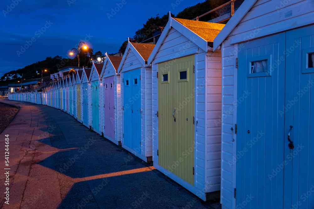 Fototapeta premium beach huts along the promenade at Lyme Regis Dorest England at dawn before sunrise