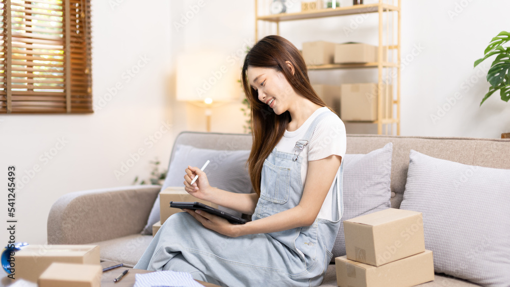 Woman uses mobile phone or tablet to chat with customers who come to order product, Freelance work at home, Conversation with customers through massage, Small business owner, SME entrepreneur. Woman uses mobile phone or tablet to chat with customers who come to order product, Freelance work at home, Conversation with customers through massage, Small business owner, SME entrepreneur.