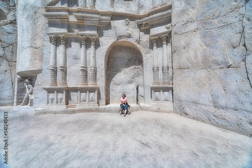 Woman sitting at the famous gate of the ashlar route (ruta del sillar) in Arequipa in Peru.