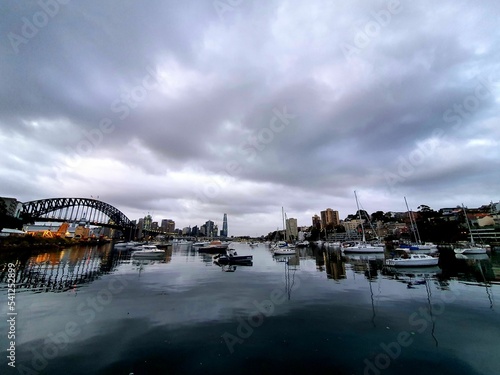 Scenic view of the Sidney harbor with its bridge yatchs ona gloomy weather © Mini12/Wirestock Creators