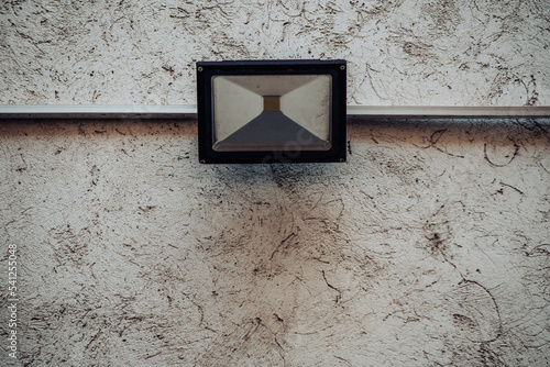 LED reflector spotlight mounted on the exterior wall of a home for safety measures photo