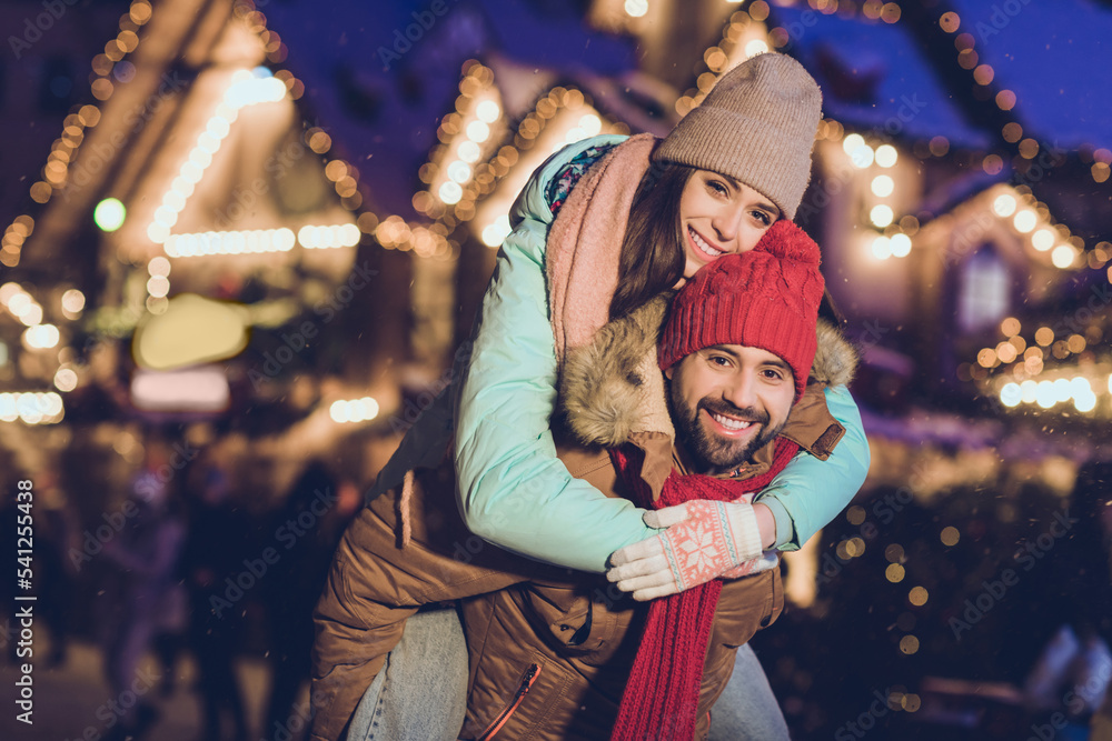 Photo of beautiful lovers young couple piggyback hug wear cap jacket scarf gloves walk on weekend