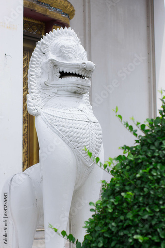 Beautiful stucco lion sculpture in front of the door of a Thai temple.