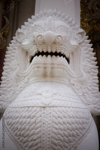 Beautiful stucco lion sculpture in front of the door of a Thai temple.