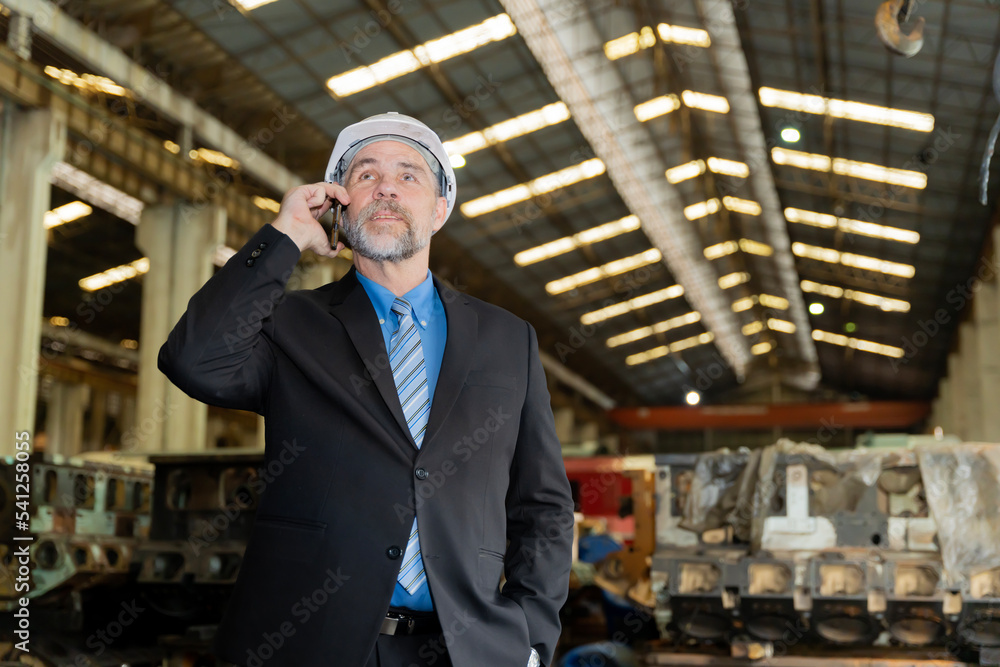 A businessman checks on-site maintenance work at an old factory A businessman checks on-site maintenance work at an old factory