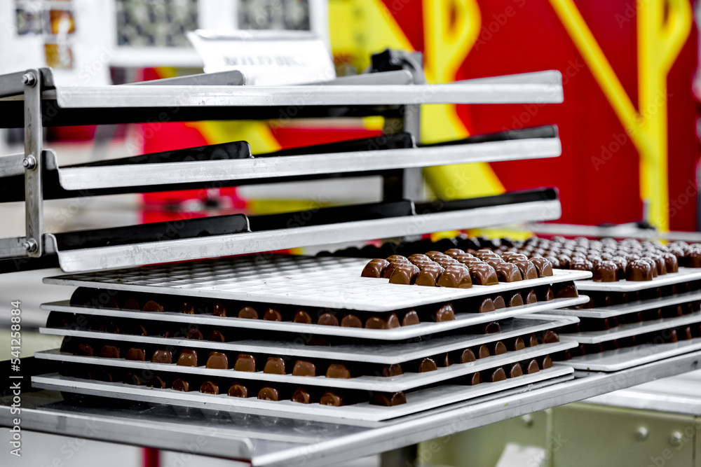 Many chocolate sweets on conveyor belt in food factory Many chocolate sweets on conveyor belt in food factory