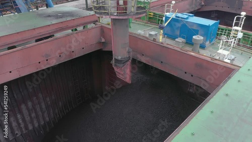 Sea ship hold is loaded by coal.