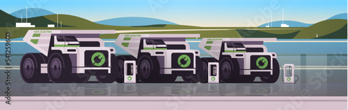 electric mining dumpers industrial trucks charging parking at the charger station with a plug in cable electrified transportation