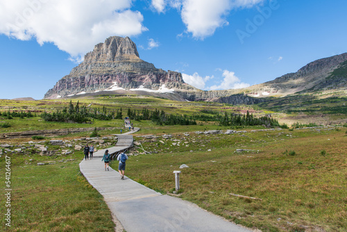 Tourist Hiking On Hidden Lake Trail with Bear Hat Mountain in the Background at Logan Pass, Glacier National Park, Montana, USA photo