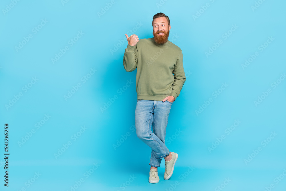 Full body photo of attractive young man stand point empty space shopping dressed stylish khaki look isolated on aquamarine color background Full body photo of attractive young man stand point empty space shopping dressed stylish khaki look isolated on aquamarine color background