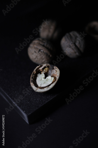 a delicious ripe walnut lies on a black kitchen cutting board. for banners of labels of the menu of culinary recipes screensavers on phones and screens of gadgets