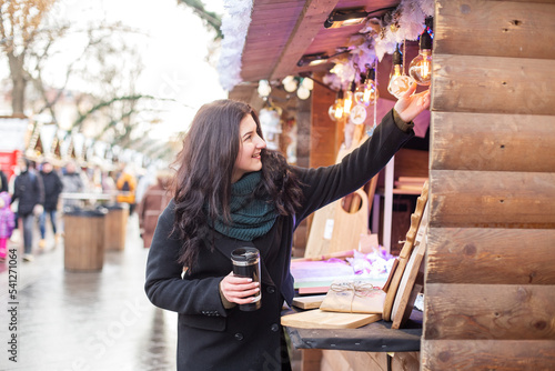 Canvas Print Happy woman buys gifts at festive Christmas market