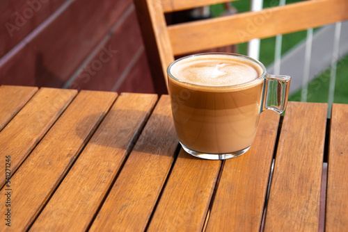 Obraz na płótnie Fresh coffee on a wooden table during breakfast. The sun falls on the cup. Time to relax w salonie