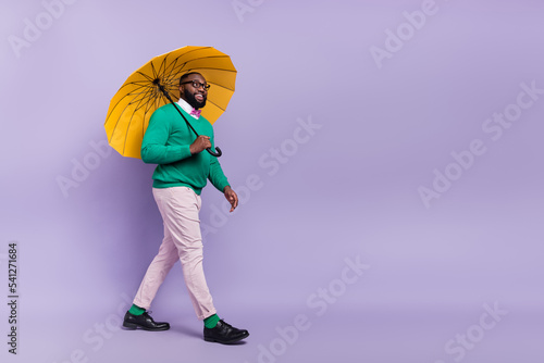 Full body image of young handsome gentleman go on romantic date under rain isolated on purple color background photo