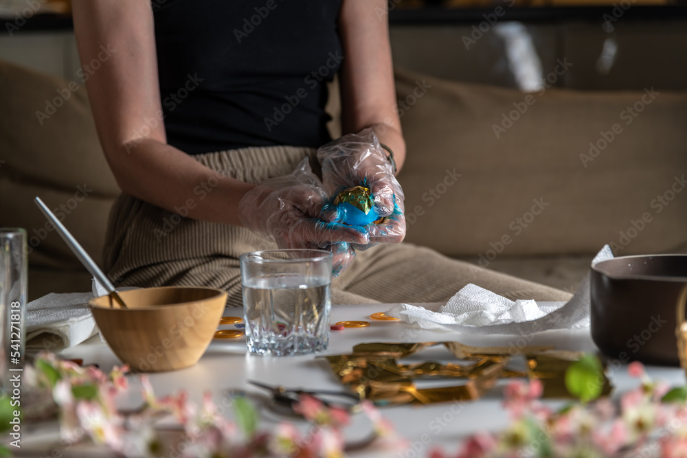 Fototapeta premium woman at home in the kitchen dyes eggs for Easter