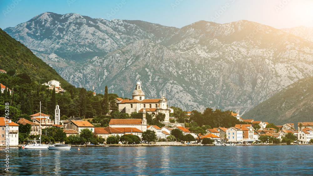 Fototapeta premium Beautiful city in Adriatic sea in Montenegro with mountains view. Scenic town with nature landscapes and Mediterranean architecture