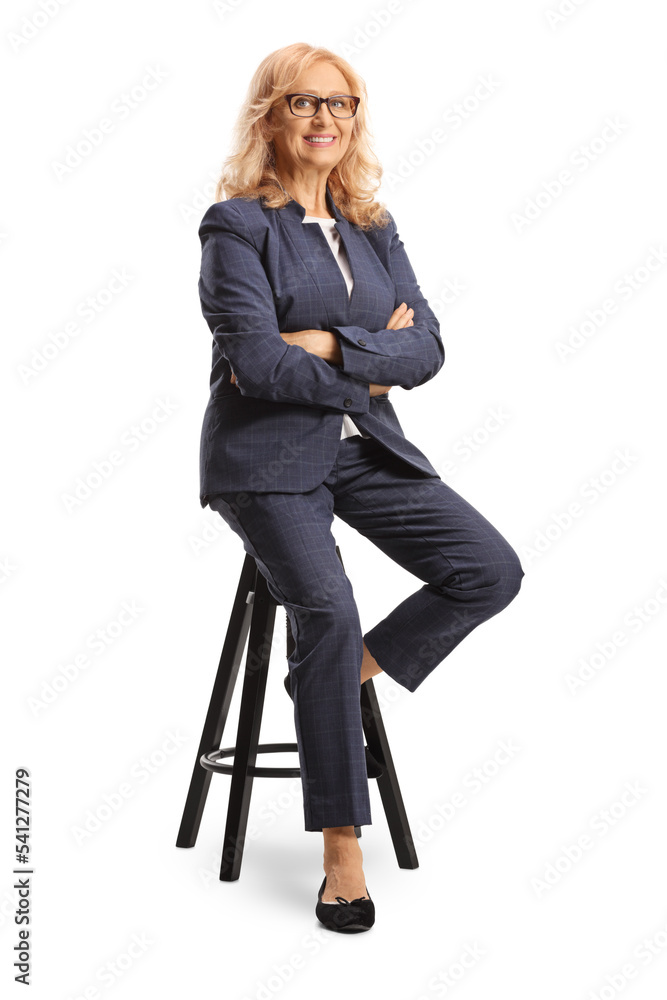 Full length portrait of a mature professional woman with glasses sitting on a chair Full length portrait of a mature professional woman with glasses sitting on a chair