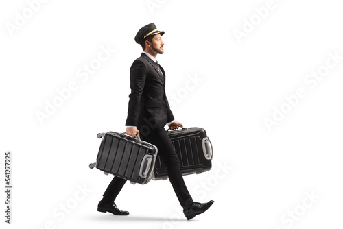 Full length profile shot of a bellboy walking and carrying two suitcases photo