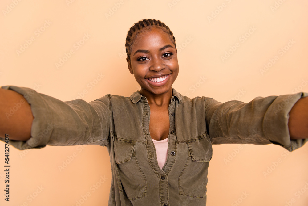 Obraz premium Portrait of positive charming lady make selfie record video toothy smile isolated on beige color background
