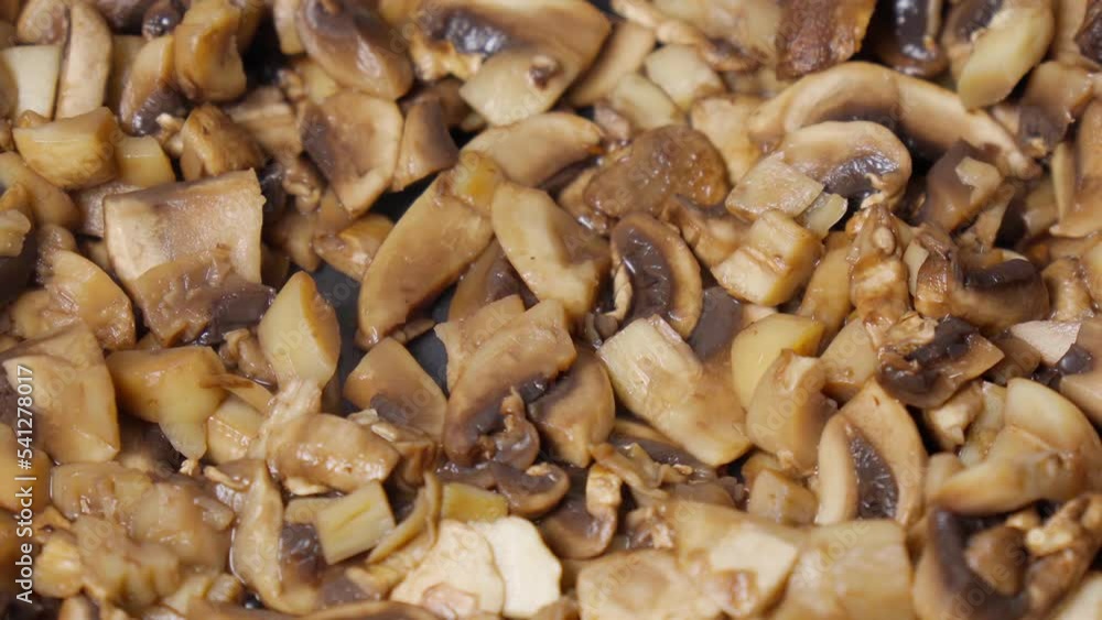 Cooking fried mushrooms, champignons in a pan. Close-up. Selective focus Cooking fried mushrooms, champignons in a pan. Close-up. Selective focus
