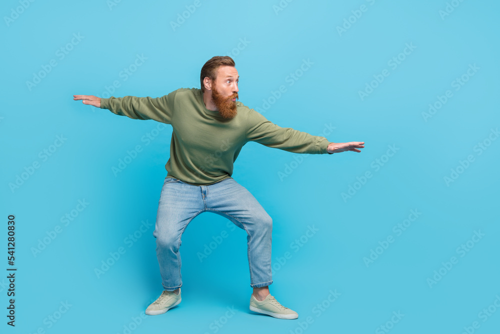 Full length photo of nice young man confident surfer have fun energetic dressed stylish khaki look isolated on aquamarine color background