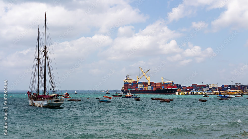Port of Zanzibar with big ships, cranes, cargo and boats in Stone Town.
