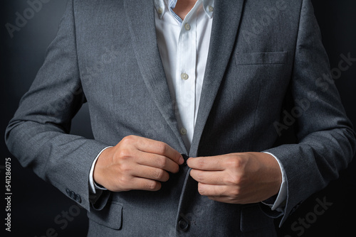 Businessman wearing a black gray suit on black background