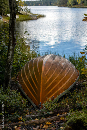 Orange overturned fibreglass boat on beach in Finland photo