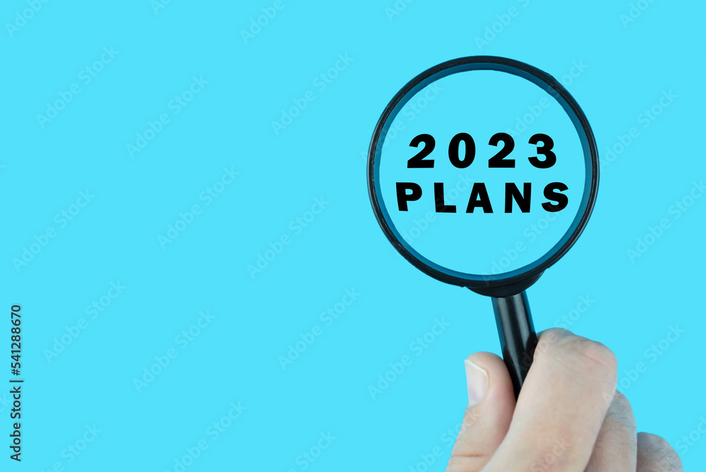 Focused on plan for next year 2023 concept. Words 2023 plans under magnifying glass. Card design. Focused on plan for next year 2023 concept. Words 2023 plans under magnifying glass. Card design.