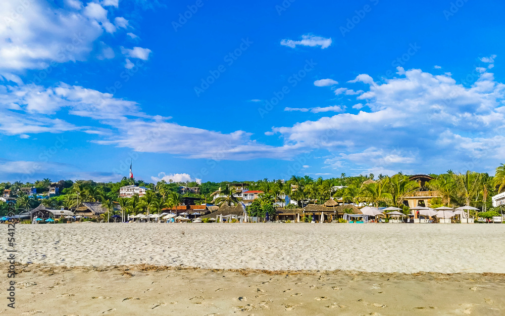 Palms parasols sun loungers beach resort Zicatela Puerto Escondido Mexico.