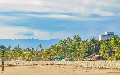 Fototapeta Naklejka Na Ścianę i Meble -  Palms parasols sun loungers beach resort Zicatela Puerto Escondido Mexico.