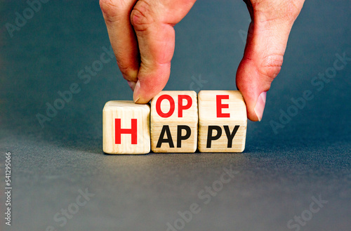 Hope and happy symbol. Concept words Hope and Happy on wooden cubes. Beautiful grey table grey background. Businessman hand. Business hope and happy concept. Copy space.