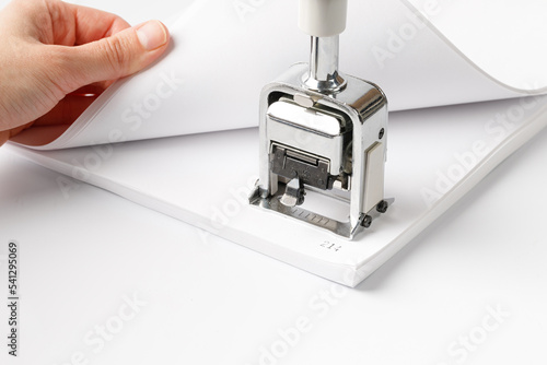 Woman stamping page numbers. To number the pages, automatic numbering system for paper. Office supplies, stationery.