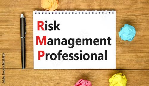 RMP risk management professional symbol. Concept words RMP risk management professional on white note on a beautiful wooden background. Business RMP risk management professional concept. Copy space. © Dzmitry