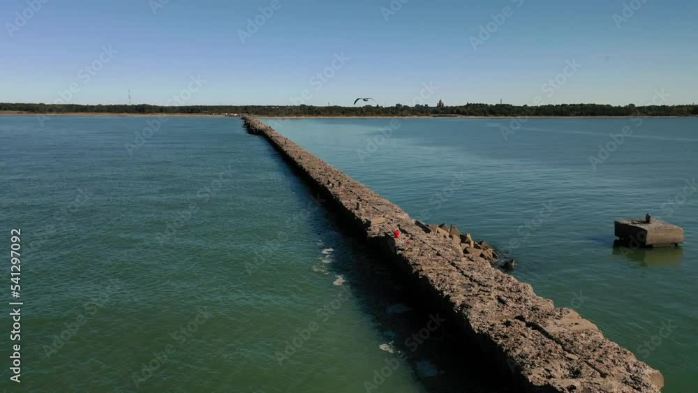 pier at the sea, sea shore, people walking to a lighthouse pier at the sea, sea shore, people walking to a lighthouse