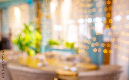 Blurred holiday background. Bokeh background of Christmas garlands. Beautiful New Year s home interior decorations. Festive table in the restaurant.