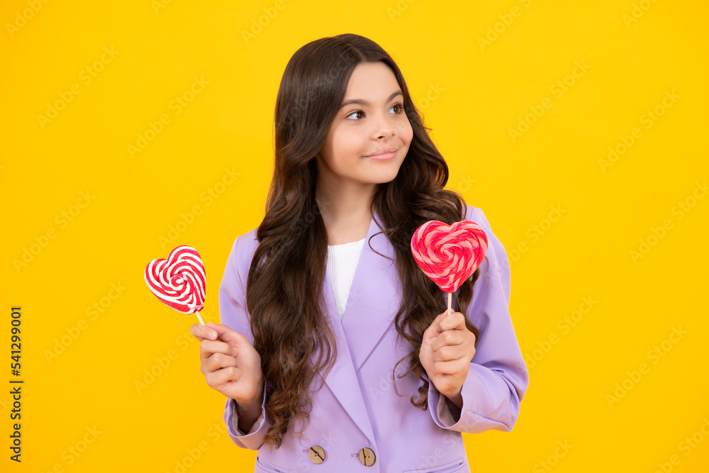 Teen girl hold lollipop caramel on yellow background, candy shop. Teenager with sweets suckers. Happy teenager, positive and smiling emotions of teen girl. Teen girl hold lollipop caramel on yellow background, candy shop. Teenager with sweets suckers. Happy teenager, positive and smiling emotions of teen girl.