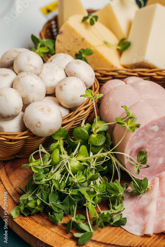 pizproducts for cooking pizza: cheese, mushrooms, ham and micro-greens