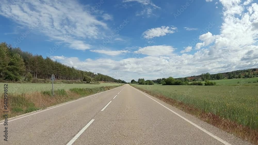 POV driving a car on empty asphalt road through fields outside the city of spanish village during sunny day. Traffic ways transportation countryside concept. POV driving a car on empty asphalt road through fields outside the city of spanish village during sunny day. Traffic ways transportation countryside concept.