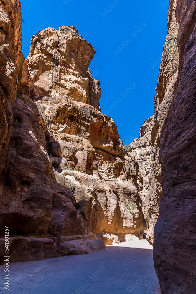 A view down the sunlit passage leading to the ancient city of Petra, Jordan in summertime