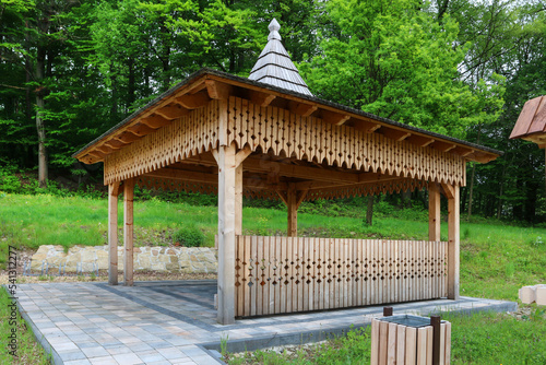 Wooden gazebo in beautiful city park.